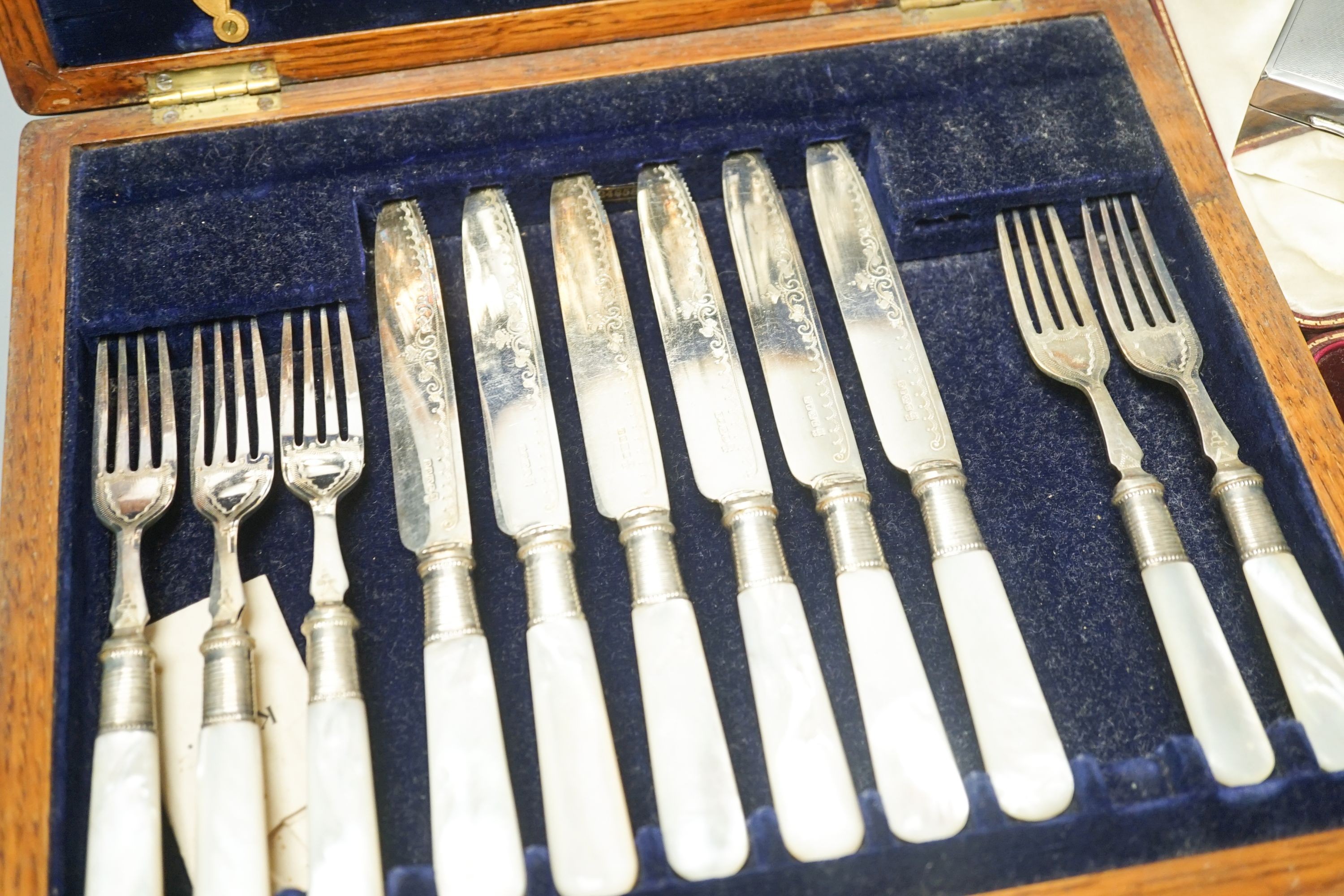 A cased set of silver teaspoons and tongs, a silver mounted cigarette case and plated part dessert service